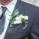 Closeup of a classy white freesia groom's boutonniere