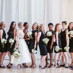 Elegant bridal party in a line holding flower bouquets.